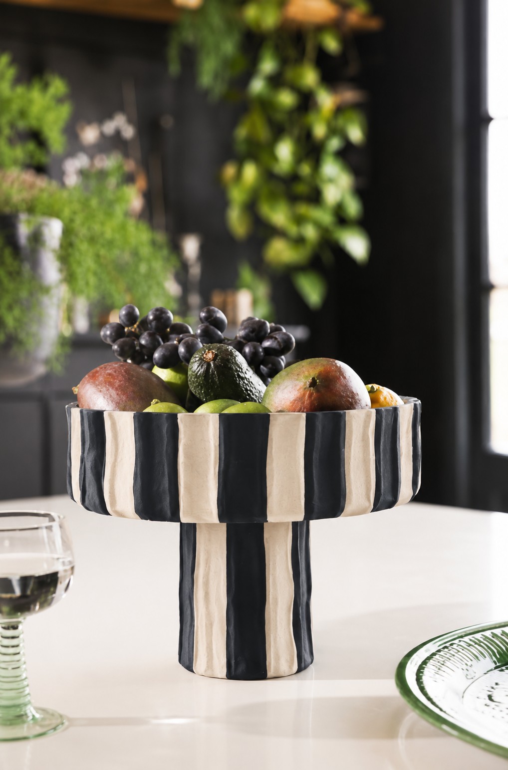 Black and white striped ceramic statement bowl, styled with fruit