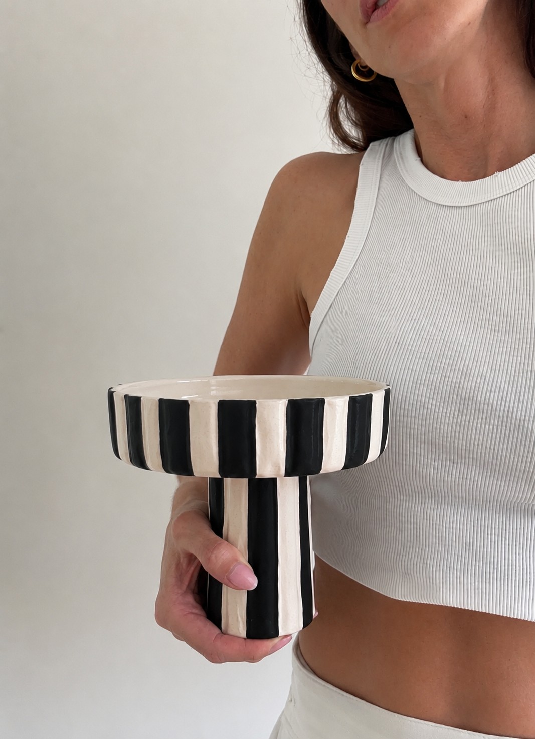 Black and white striped ceramic statement bowl, held